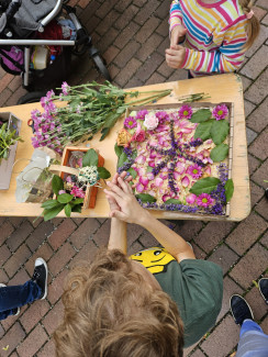 Kinder beim gestalten des Blumenteppichs